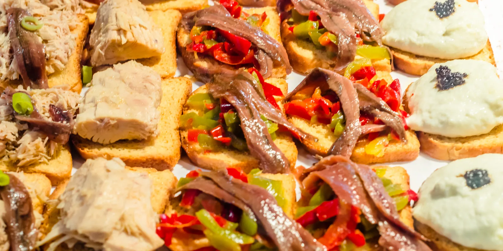 Barra de un bar de tapas del centro de Sevilla con montaditos y tapas servidas sobre el mostrador