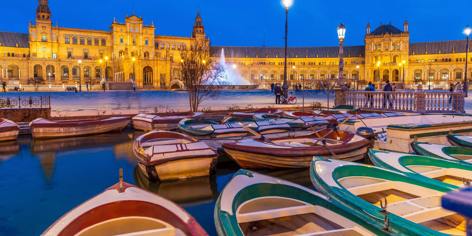 Familia con dos niños en una barca de remos en el canal de la Plaza de España de Sevilla