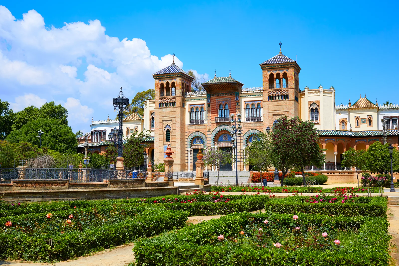Pabellón mudéjar con torres entre parterres de rosales y palmeras
